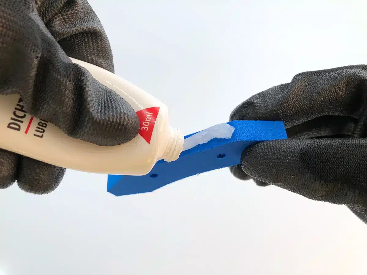 Applying grease to a blue object