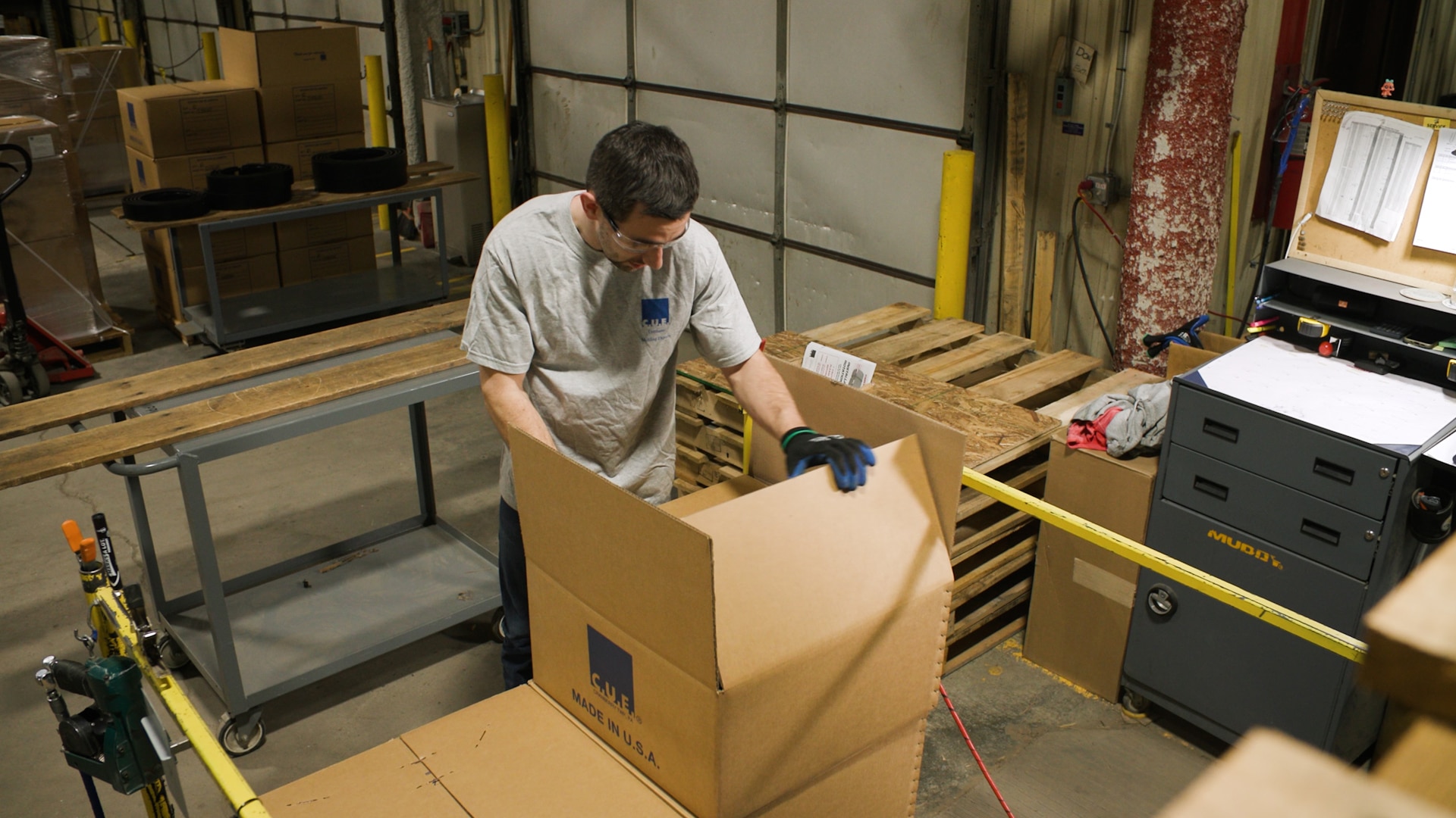 Person assembling cardboard boxes indoors.