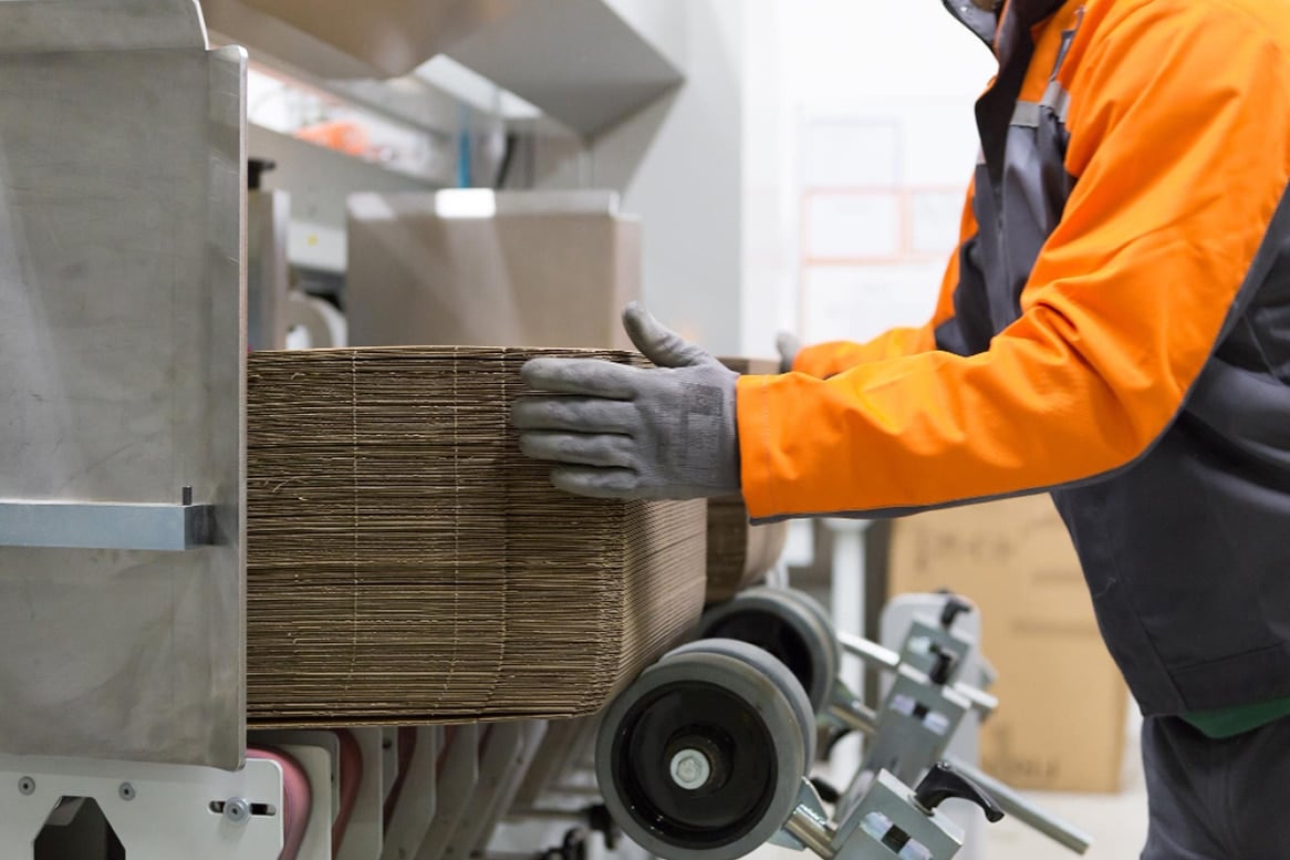 Worker handling cardboard packaging materials